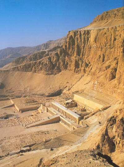 The agricultural Nile floodplain gives way abruptly to deserts and rugged hills, as illustrated in this view of Deir el-Bahari, an area of Western Thebes. The mortuary temples of the pharaohs Hatshepsut and Nebhepetre Mentuhotep II are in the foreground ..... Photograph: Ancient Egypt -- General Editor David Silverman -- Oxford University Press -- ISBN: 0195212703